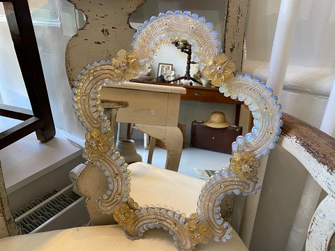 Venetiansk spejl med fine rosetter med gyldne stænk samt et blåligt skær i det hvide glas. Produceret i midten af det 20. århudrede