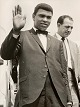 Vintage pressefoto af bokseren Muhammad Ali / Cassius Clay (1942 - 2016), der vinker ved ankomst til London Airport til kampen mod Henry Cooper i 1966