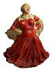 Figur af kvinde i rød kjole med stort svaj og sjal med valmuer udført i beton eller lignende tungt materiale.